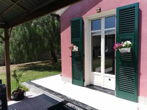 una casa rosa con persianas verdes y flores en la puerta en B&B al N.9, en Pontedassio