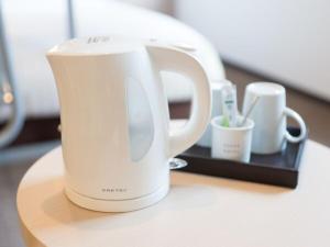 eine weiße Kaffeekanne auf einem Tisch in der Unterkunft Super Hotel Tokyo Kinshicho Ekimae / Vacation STAY 78889 in Tokio
