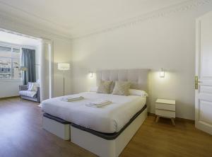 巴塞隆納的住宿－SibsBcn-PaseodeGracia Luxury Exclusive Gaudi，白色卧室配有一张大床和椅子