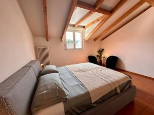 een slaapkamer met een bed in een kamer met een raam bij Cozy Ascona: attico mansardato in Ascona