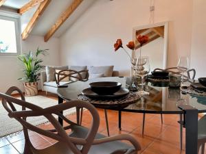 een woonkamer met een tafel en een bank bij Cozy Ascona: attico mansardato in Ascona