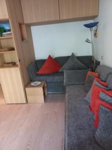 a living room with a blue couch with red pillows at Riva del Garda in Riva del Garda