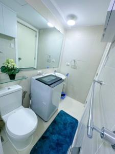 a bathroom with a toilet and a shower and a blue rug at LA CASA ALEYKA AZURE NORTH PAMPANGA BALI Tower 518 in San Fernando