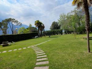 a stone path in a park with a palm tree at Riva del Garda in Riva del Garda