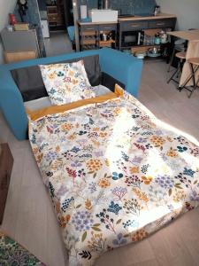 uma cama com um cobertor em cima em Le grenier de Mamou em Hesdigneul-lès-Boulogne