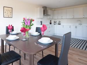 a kitchen with a wooden table with pink flowers on it at Pass the Keys Chestnut Cottage parking stunning views in Chipping Campden