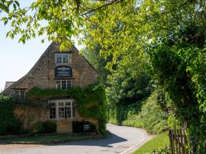 un ancien bâtiment en pierre avec un chemin menant à celui-ci dans l'établissement Pass the Keys Chestnut Cottage parking stunning views, à Chipping Campden