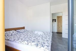 sypialnia z łóżkiem z niebiesko-białą kołdrą w obiekcie Varsovia Residence apartament 19 Parking w Elblągu