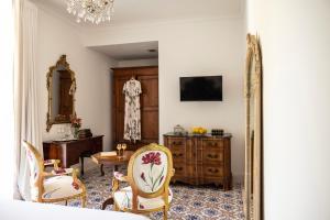 a living room with a table and chairs and a mirror at Villa De Cillis Carafa in Torre del Greco
