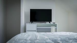 a bedroom with a television on a white cabinet at Short City Stays in Hunslet
