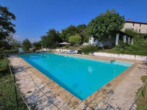 una gran piscina azul en un patio en Attractive apartment in old farmhouse on the estate with pool, en Umbertide