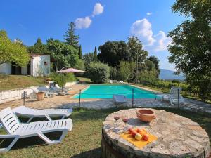 een tafel met fruit erop naast een zwembad bij Attractive apartment in old farmhouse on the estate with pool in Umbertide