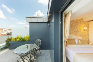a room with a balcony with a bed and a table at Hallmark Hotel & SPA Istanbul in Istanbul