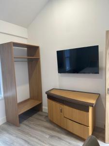 a room with a desk and a tv on a wall at Newland Park Bungalow Near Hull Uni Free Parking Free Wi-Fi in Hull