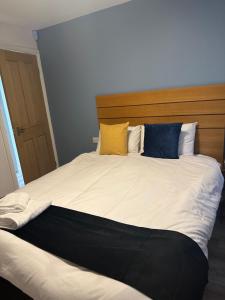 uma cama grande com quatro almofadas em cima em Newland Park Bungalow Near Hull Uni Free Parking Free Wi-Fi em Hull