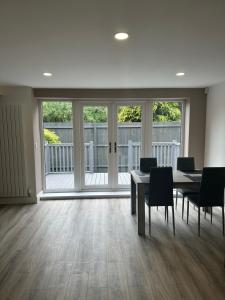 a dining room with a table and chairs and windows at Newland Park Bungalow Near Hull Uni Free Parking Free Wi-Fi in Hull