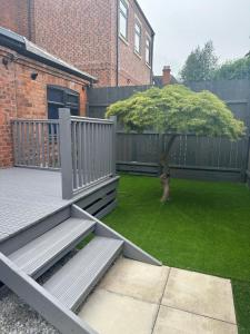 a backyard with a deck with a tree on it at Newland Park Bungalow Near Hull Uni Free Parking Free Wi-Fi in Hull