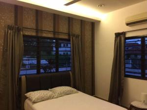 ein Schlafzimmer mit einem Bett und einem großen Fenster in der Unterkunft Melaka Beach Villa in Malakka