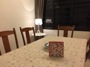 einen Tisch mit einem weißen Tischtuch und einer Schachtel darauf. in der Unterkunft Melaka Beach Villa in Malakka
