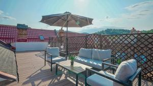 a patio with two chairs and an umbrella on a deck at Rooftop proprety with Large Terrace & Stunning Views - Brașov in Braşov