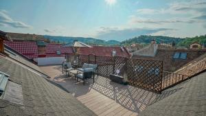 een balkon met een tafel en stoelen op een dak bij Comfort Apartment Rooftop Brasov in Braşov