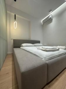 a large bed in a room with a white wall at Center Apartment in Tirana