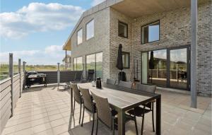 スナーヴィグにあるBeautiful Home In Ringkbing With House A Panoramic Viewのパティオ(テーブル、椅子付)