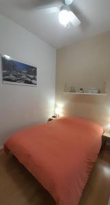a bedroom with a bed with a red bedspread at Appartement T2 hyper centre Luchon in Luchon