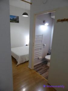 a bedroom with a bed and a bathroom with a toilet at Appartement T2 hyper centre Luchon in Luchon