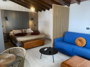 a living room with a blue couch and a bed at Murmuria Taormina in Taormina
