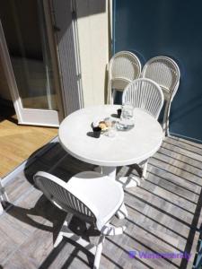 una mesa blanca y sillas en un patio en Appartement T2 hyper centre Luchon en Luchon