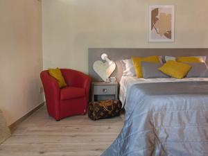 1 dormitorio con 1 cama y 1 silla roja en Modern Apartment in Agliana with Shared Garden, en Agliana