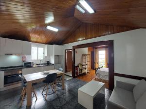 a kitchen and living room with a table and a couch at 3A Botanical Dimensions Nature Terraces BBQ in Faial