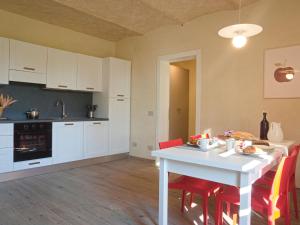 cocina con mesa blanca y sillas rojas en Modern Apartment in Agliana with Shared Garden, en Agliana