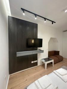 a living room with a flat screen tv and a couch at Center Apartment in Tirana