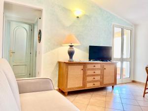 una sala de estar con TV en una cómoda de madera en Casagliana Apartments, en Golfo Aranci
