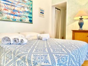 1 dormitorio con 1 cama con colcha azul y blanca en Casagliana Apartments, en Golfo Aranci