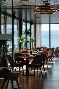 uma sala de jantar com mesas, cadeiras e janelas em Hotel Medistone em Omiš