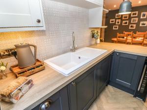 a kitchen with blue cabinets and a white sink at 15 Market Place in Barnard Castle