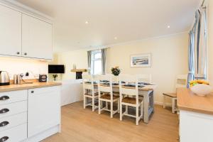 a kitchen and dining room with a table and chairs at High Auchenlarie Cottage in Gatehouse of Fleet
