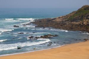 einen Strand mit Felsen im Wasser und dem Meer in der Unterkunft Well Hotel & Spa in Maceira