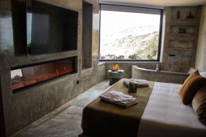 a bedroom with a bed with a fireplace and a tv at Well Hotel & Spa in Maceira