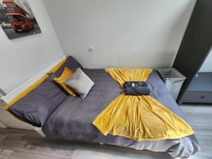 un letto con un vestito giallo sopra di Cosy Studio Wembley Stadium Gem a Wembley