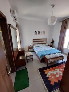 1 dormitorio con cama y espejo en Amwaj Resort امواج الساحل الشمالى 2 نوم 2 حمام, en El Alamein