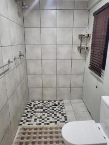 a bathroom with a toilet and a tiled shower at 9 on Oostersee in Cape Town
