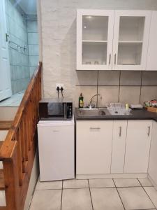 una cocina con armarios blancos y fregadero en 9 on Oostersee en Ciudad del Cabo