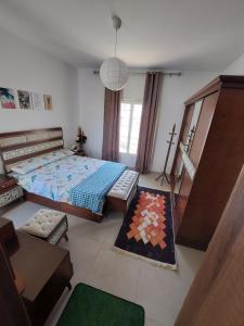 1 dormitorio con 1 cama y 1 cruz en la pared en Amwaj Resort امواج الساحل الشمالى 2 نوم 2 حمام, en El Alamein