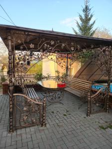 um pavilhão com um banco e uma mesa num pátio em Аренда дома em Durleşti