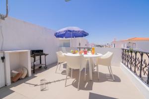 een tafel en stoelen op een balkon met een parasol bij Casinha I by Innkeeper in Guia