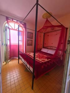 - une chambre avec un lit à baldaquin dans l'établissement Dar Alouane, à Essaouira